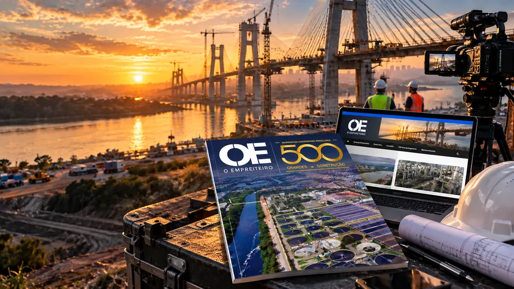 Edição da Revista O Empreiteiro e o portal exibido em um notebook, sobre uma mesa de projeto